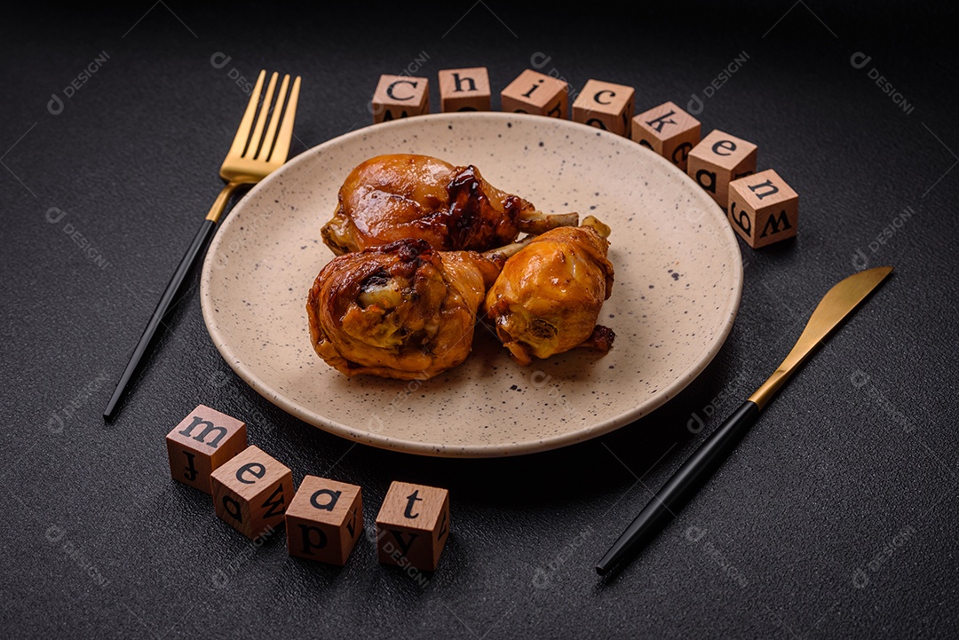 Delicioso prato asiático com pernas de frango em molho teriyaki com sal e especiarias sobre um fundo escuro de concreto