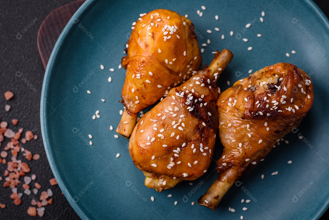 Delicioso prato asiático com pernas de frango em molho teriyaki com sal e especiarias sobre um fundo escuro de concreto