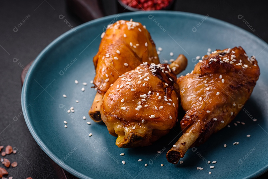 Delicioso prato asiático com pernas de frango em molho teriyaki com sal e especiarias sobre um fundo escuro de concreto