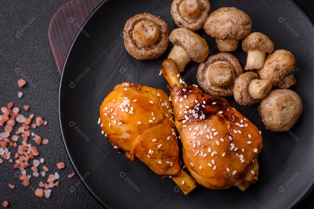 Delicioso prato asiático com pernas de frango em molho teriyaki com sal e especiarias sobre um fundo escuro de concreto