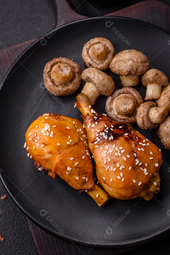 Deliciosos champignon inteiros e suculentos assados ​​na grelha com sal e especiarias em uma placa de cerâmica sobre um fundo escuro de concreto