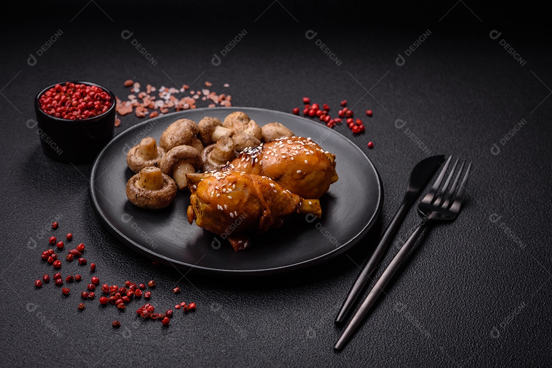 Deliciosos champignon inteiros e suculentos assados ​​na grelha com sal e especiarias em uma placa de cerâmica sobre um fundo escuro de concreto