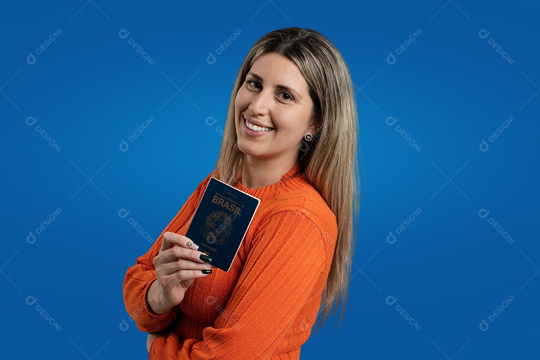 Mulher feliz sorrindo, olhando para a câmera contra um fundo azul.