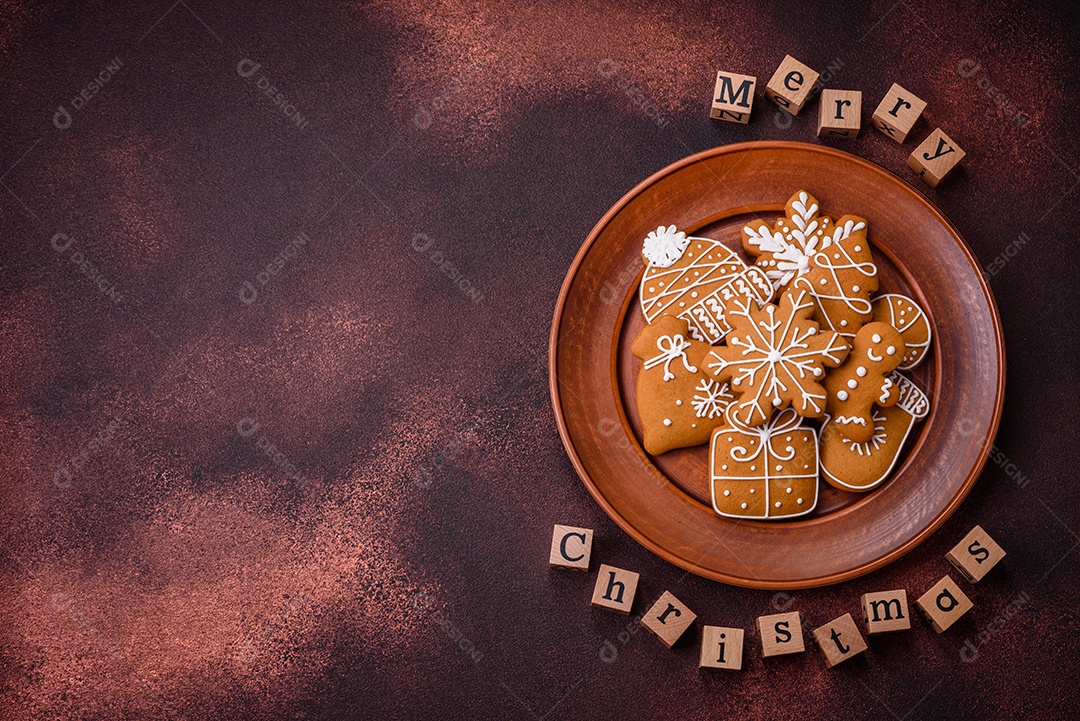 Lindos e deliciosos biscoitos de gengibre de Natal de inverno em um fundo texturizado de bronze.