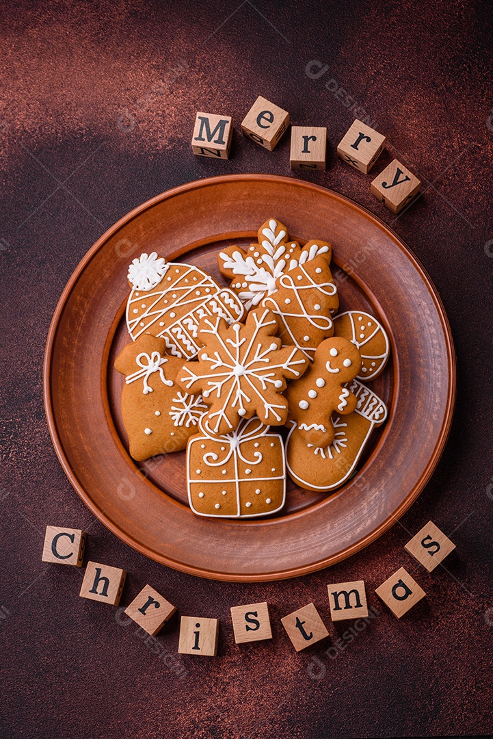 Lindos e deliciosos biscoitos de gengibre de Natal de inverno em um fundo texturizado de bronze.