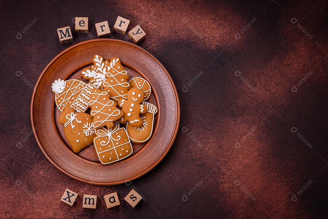 Lindos e deliciosos biscoitos de gengibre de Natal de inverno em um fundo texturizado de bronze.