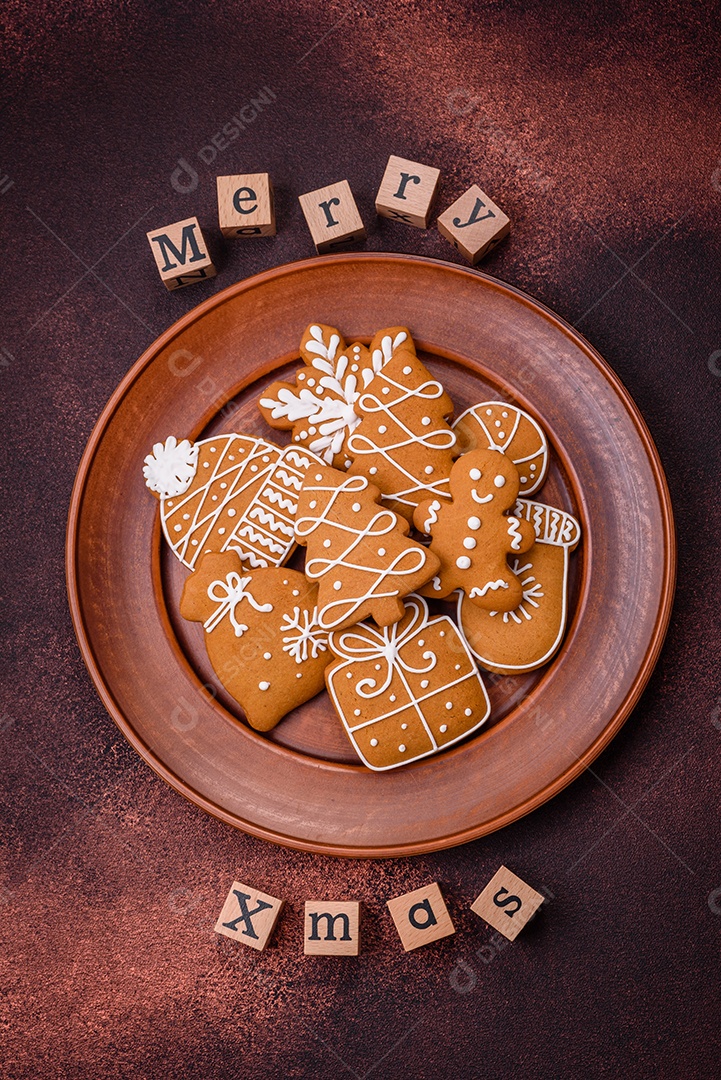 Lindos e deliciosos biscoitos de gengibre de Natal de inverno em um fundo texturizado de bronze.