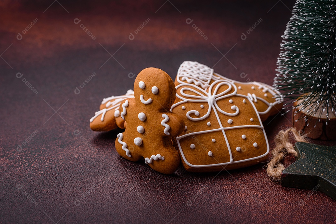 Lindos e deliciosos biscoitos de gengibre de Natal de inverno em um fundo texturizado de bronze.