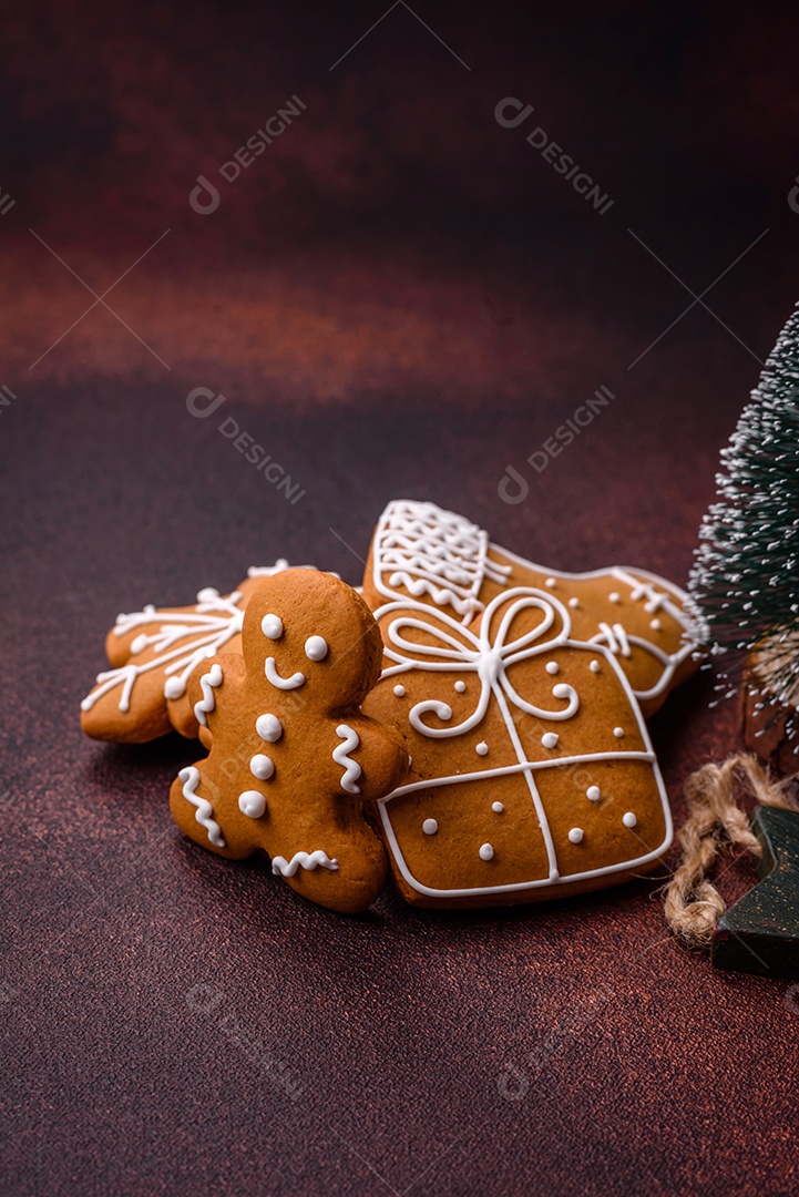 Lindos e deliciosos biscoitos de gengibre de Natal de inverno em um fundo texturizado de bronze.