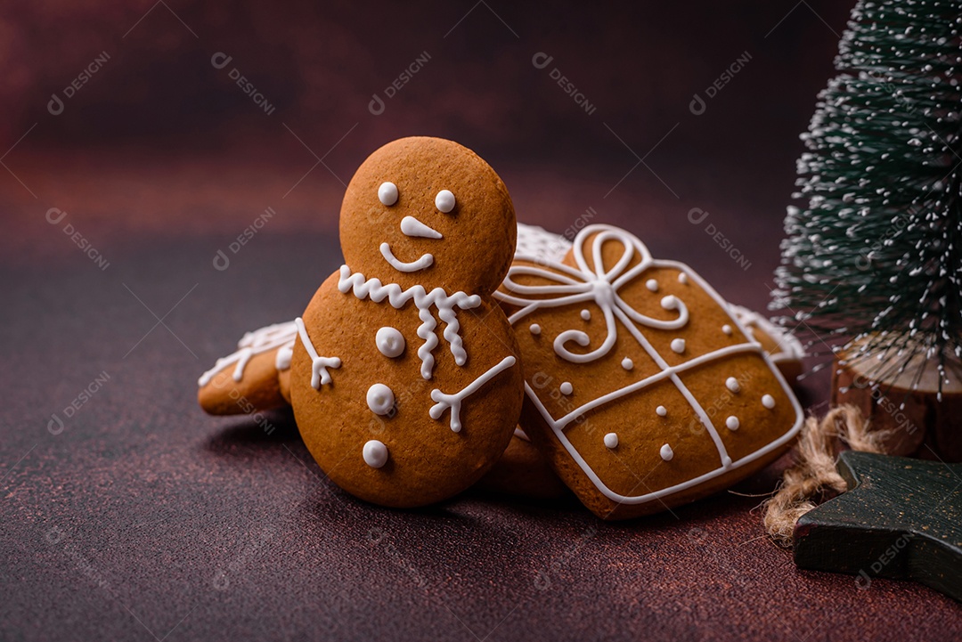 Lindos e deliciosos biscoitos de gengibre de Natal de inverno em um fundo texturizado de bronze.