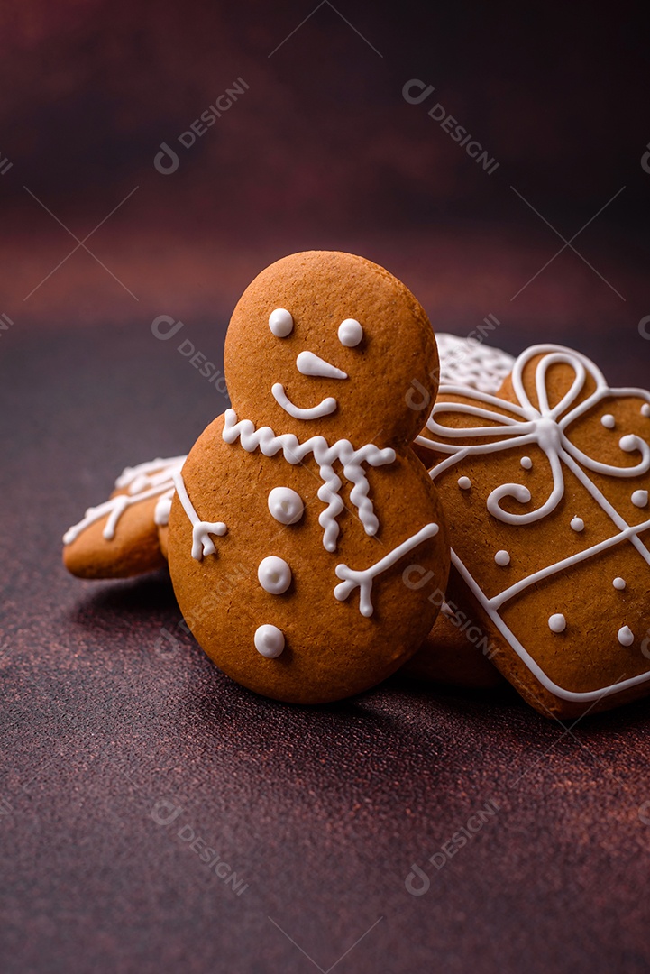 Lindos e deliciosos biscoitos de gengibre de Natal de inverno em um fundo texturizado de bronze.