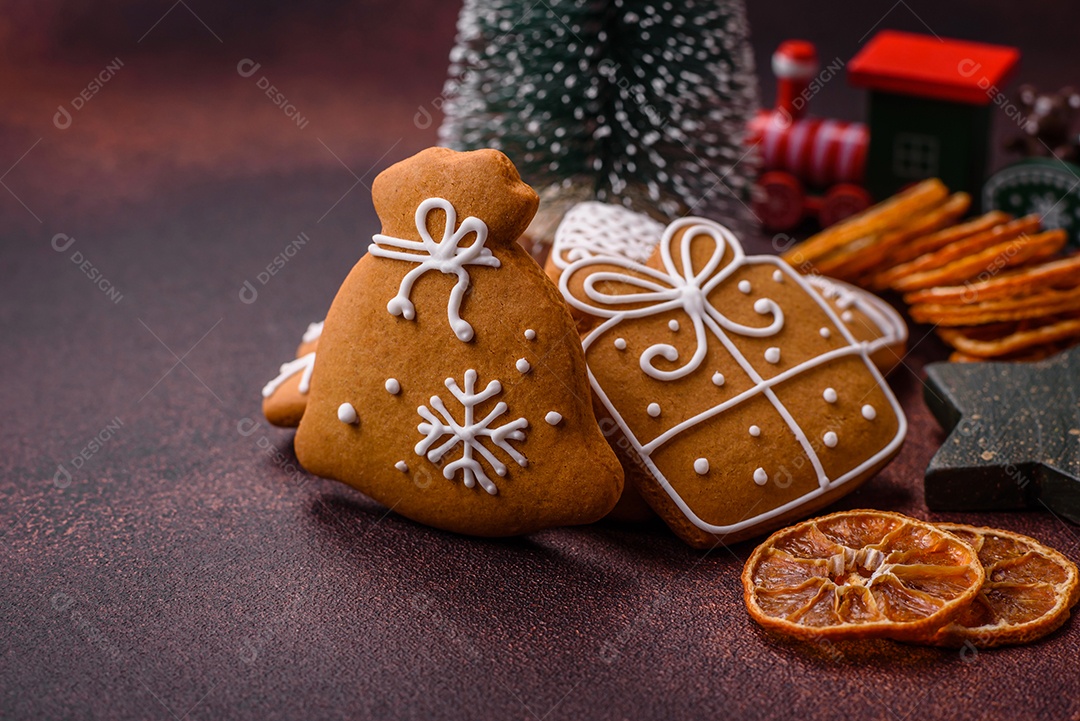 Lindos e deliciosos biscoitos de gengibre de Natal de inverno em um fundo texturizado de bronze.