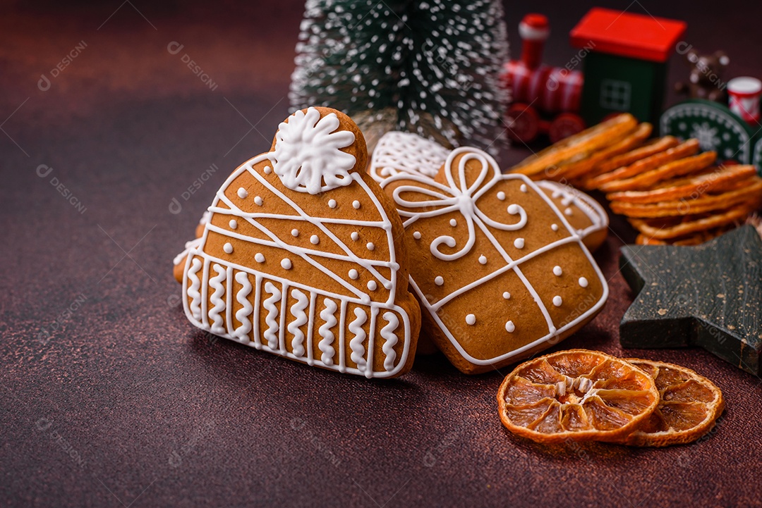 Lindos e deliciosos biscoitos de gengibre de Natal de inverno em um fundo texturizado de bronze.