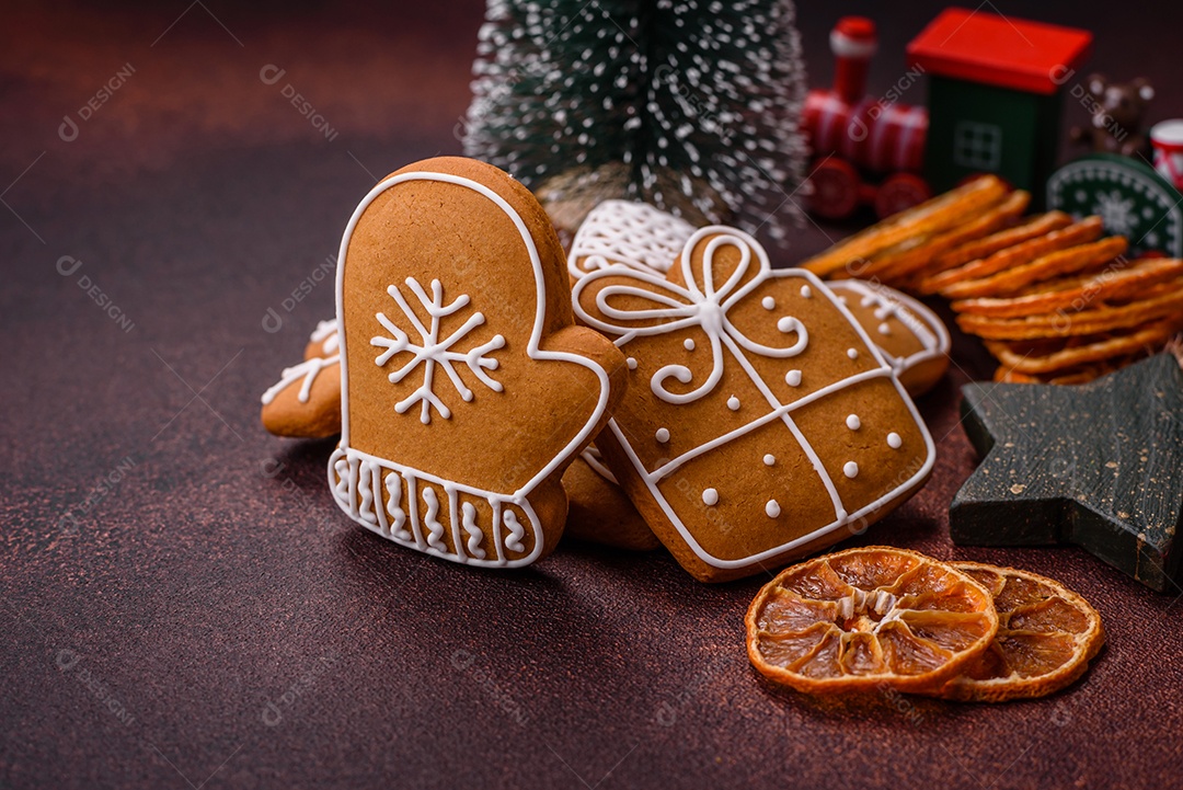 Lindos e deliciosos biscoitos de gengibre de Natal de inverno em um fundo texturizado de bronze.