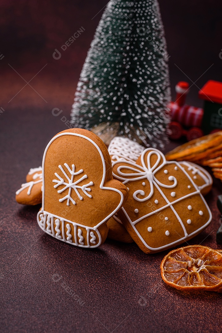 Lindos e deliciosos biscoitos de gengibre de Natal de inverno em um fundo texturizado de bronze.