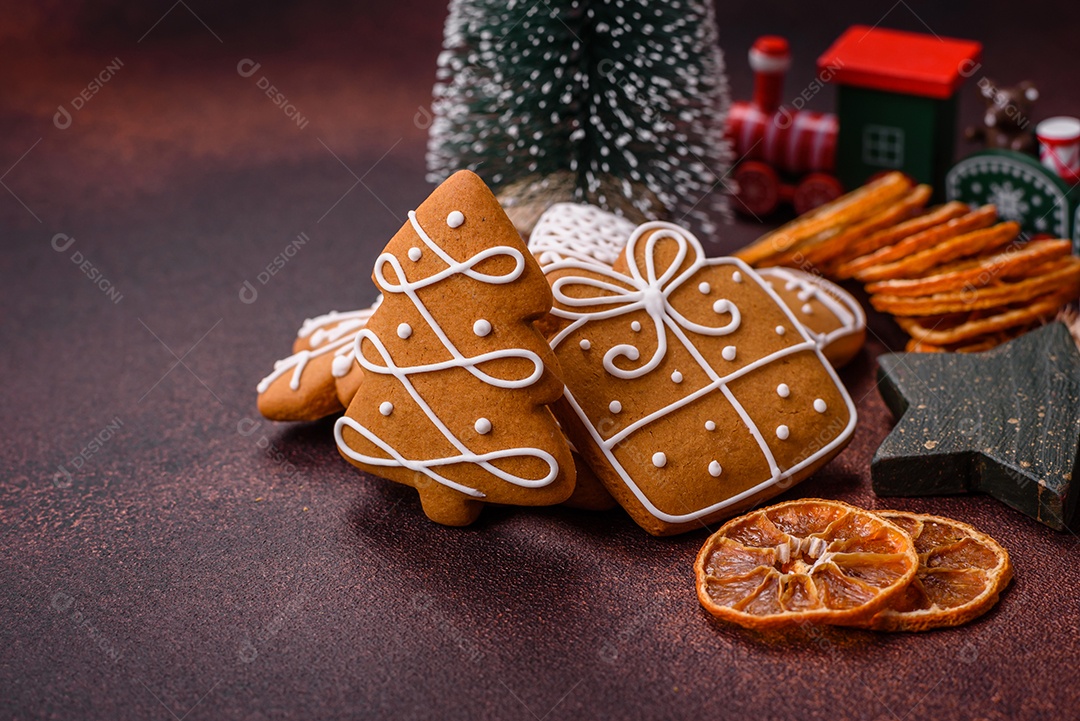 Lindos e deliciosos biscoitos de gengibre de Natal de inverno em um fundo texturizado de bronze.