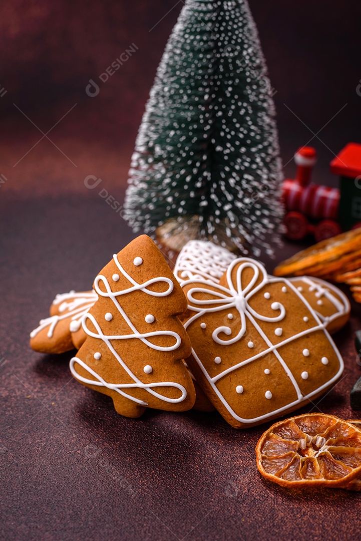 Lindos e deliciosos biscoitos de gengibre de Natal de inverno em um fundo texturizado de bronze.