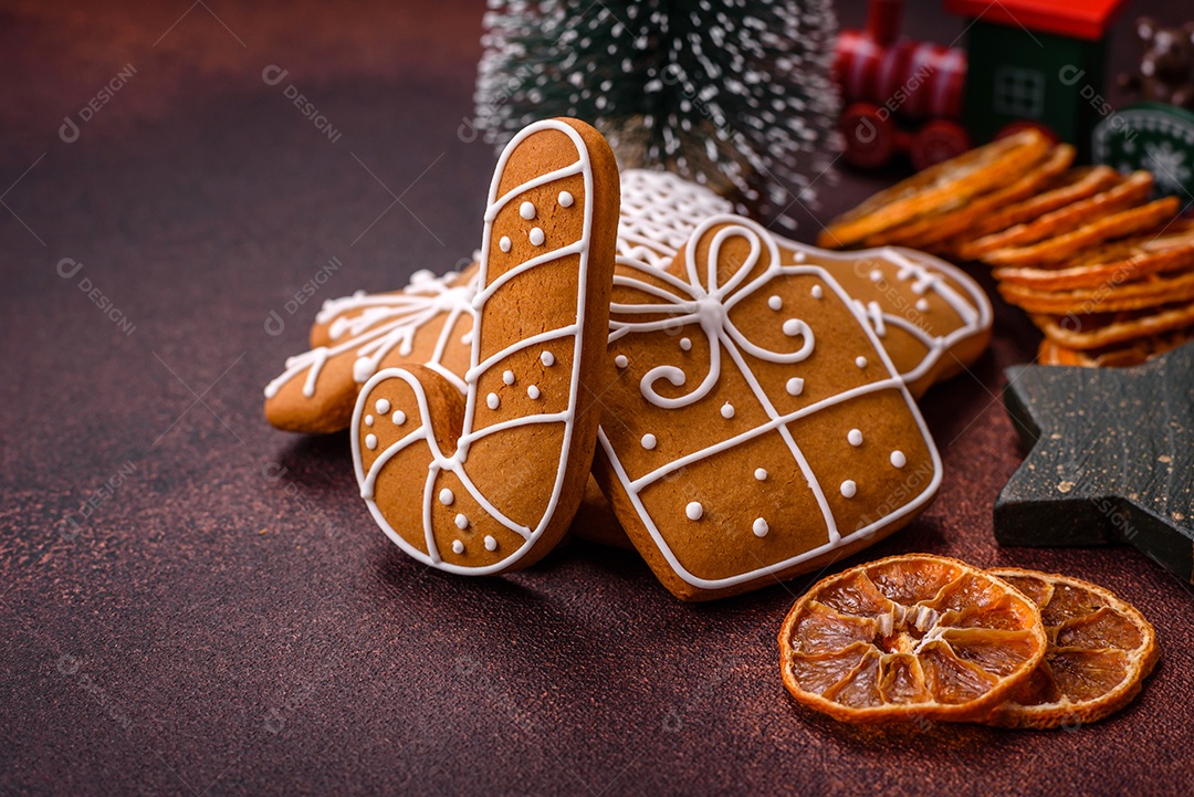 Lindos e deliciosos biscoitos de gengibre de Natal de inverno em um fundo texturizado de bronze.