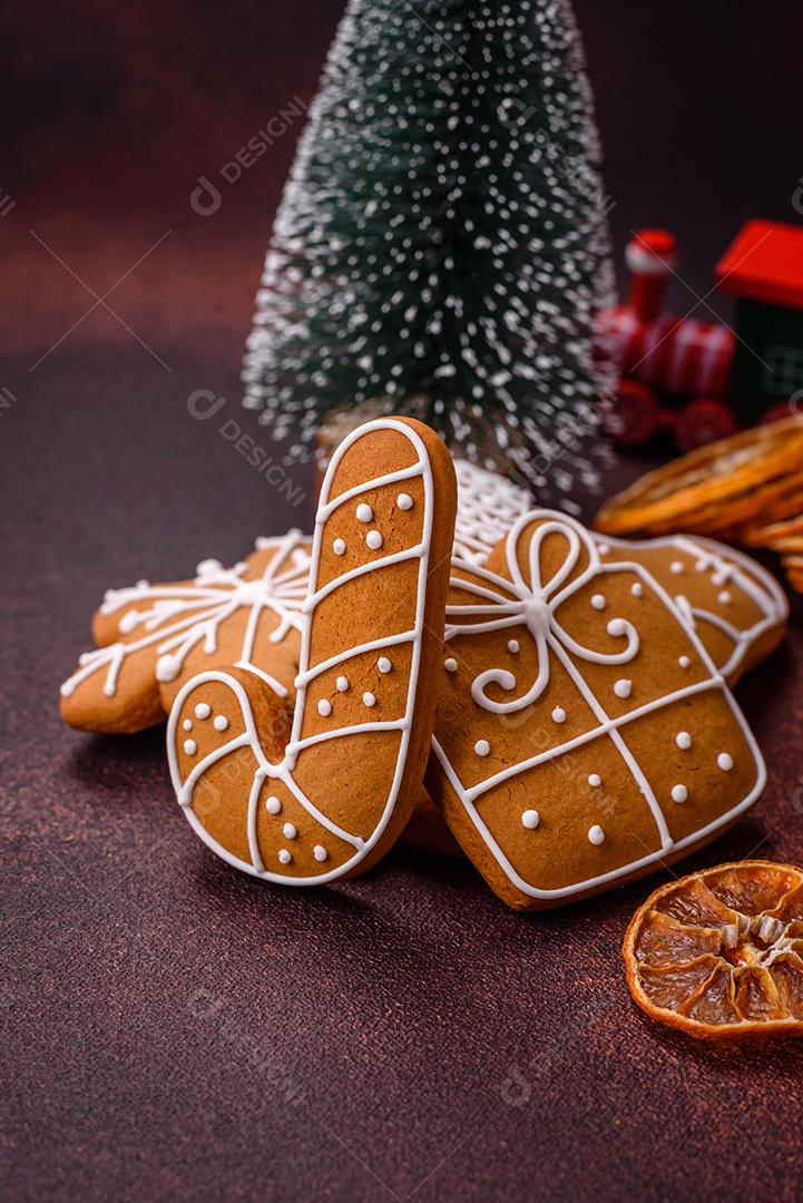 Lindos e deliciosos biscoitos de gengibre de Natal de inverno em um fundo texturizado de bronze.