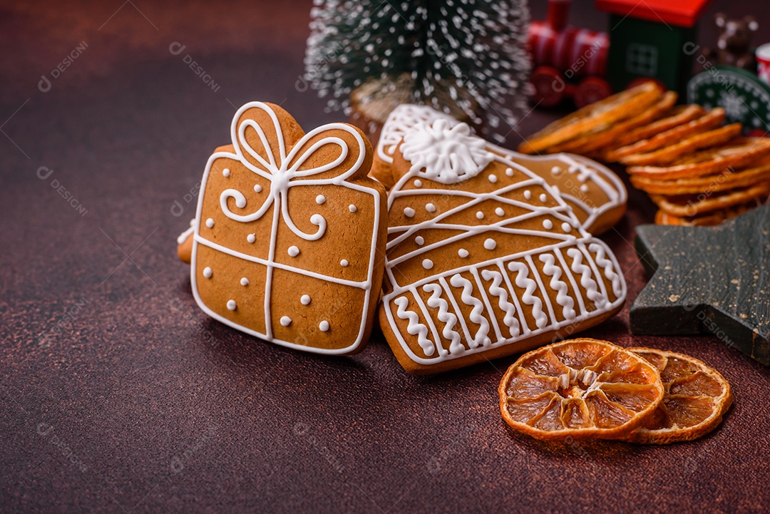 Lindos e deliciosos biscoitos de gengibre de Natal de inverno em um fundo texturizado de bronze.