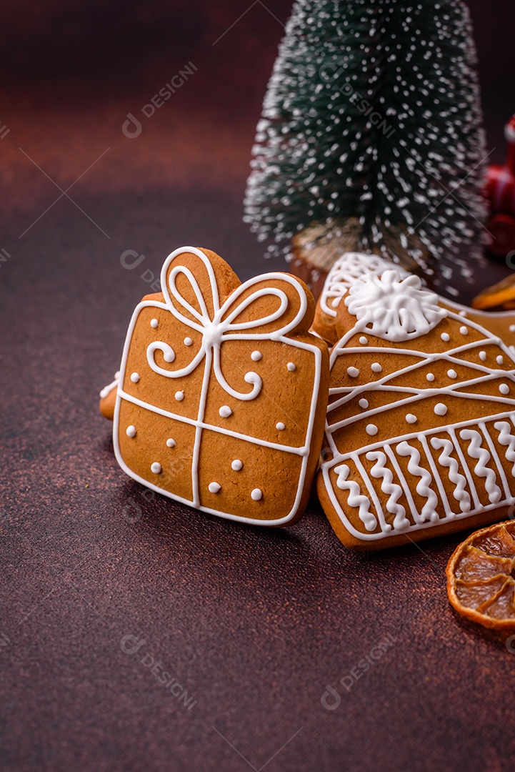 Lindos e deliciosos biscoitos de gengibre de Natal de inverno em um fundo texturizado de bronze.