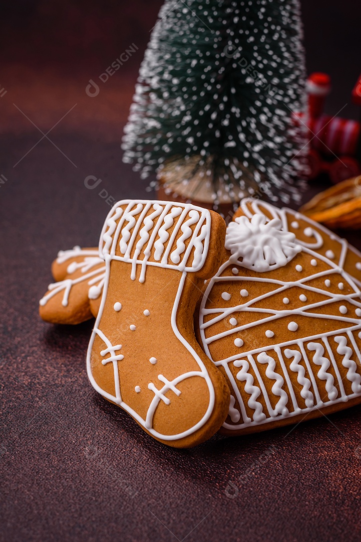 Lindos e deliciosos biscoitos de gengibre de Natal de inverno em um fundo texturizado de bronze.