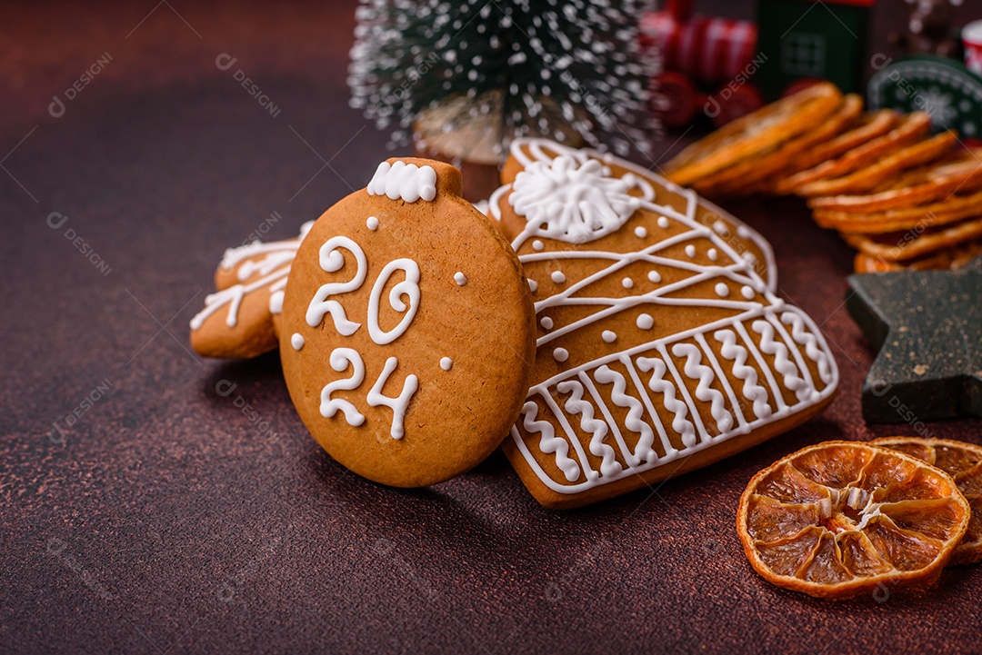 Lindos e deliciosos biscoitos de gengibre de Natal de inverno em um fundo texturizado de bronze.