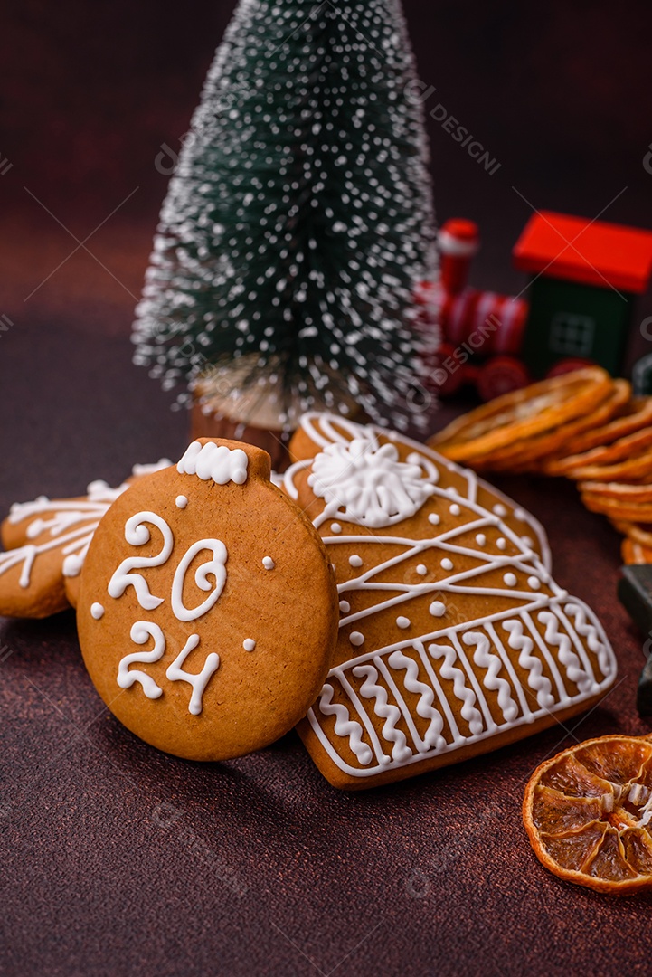 Lindos e deliciosos biscoitos de gengibre de Natal de inverno em um fundo texturizado de bronze.