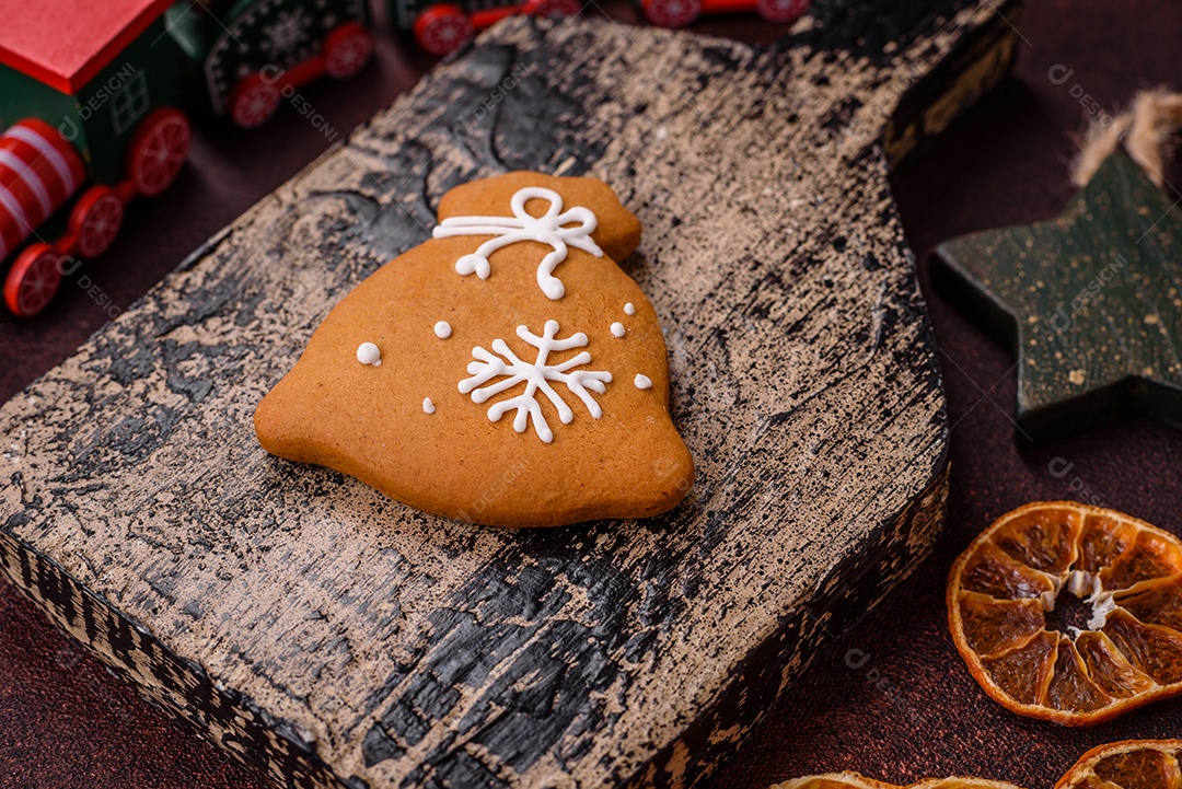 Lindos e deliciosos biscoitos de gengibre de Natal de inverno em um fundo texturizado de bronze.