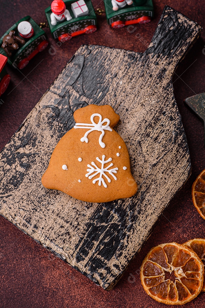 Lindos e deliciosos biscoitos de gengibre de Natal de inverno em um fundo texturizado de bronze.