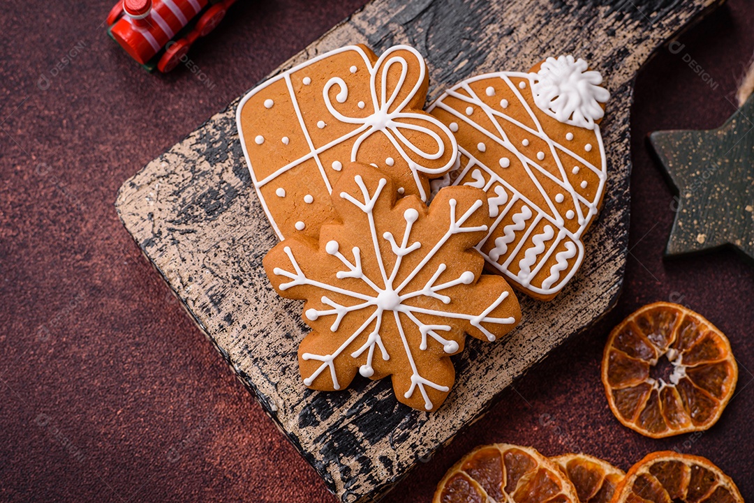 Lindos e deliciosos biscoitos de gengibre de Natal de inverno em um fundo texturizado de bronze.