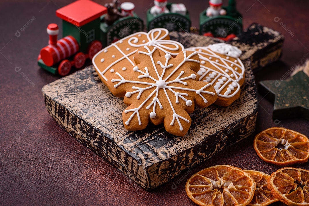 Lindos e deliciosos biscoitos de gengibre de Natal de inverno em um fundo texturizado de bronze.