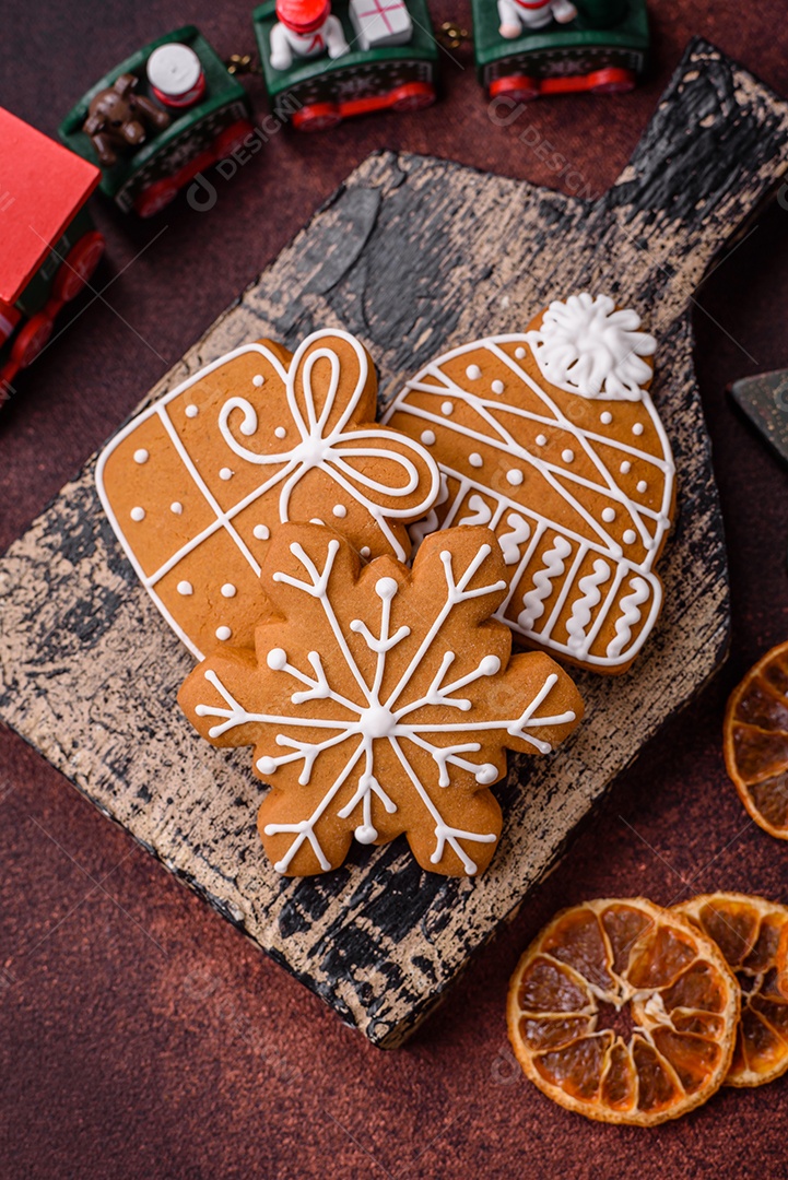 Lindos e deliciosos biscoitos de gengibre de Natal de inverno em um fundo texturizado de bronze.