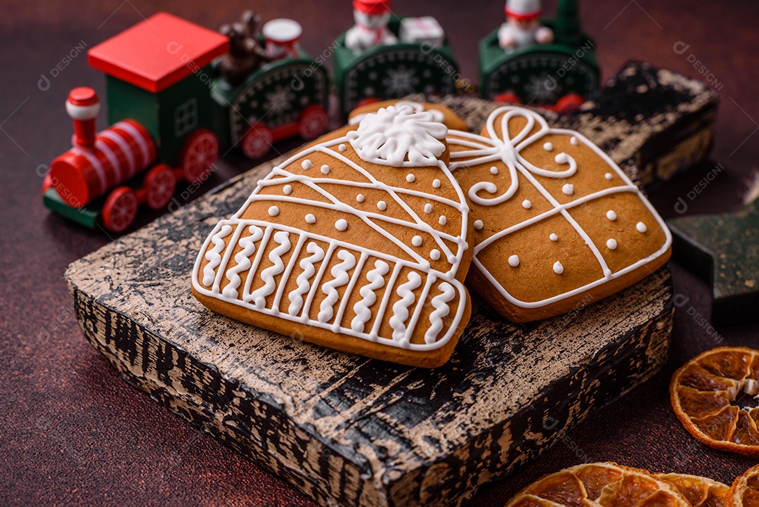 Lindos e deliciosos biscoitos de gengibre de Natal de inverno em um fundo texturizado de bronze.