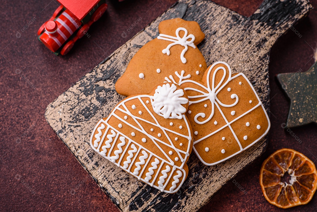Lindos e deliciosos biscoitos de gengibre de Natal de inverno em um fundo texturizado de bronze.