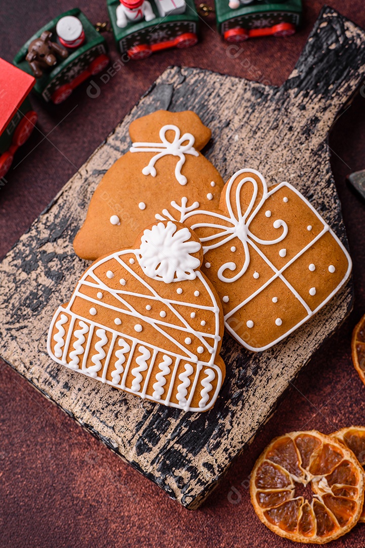 Lindos e deliciosos biscoitos de gengibre de Natal de inverno em um fundo texturizado de bronze.