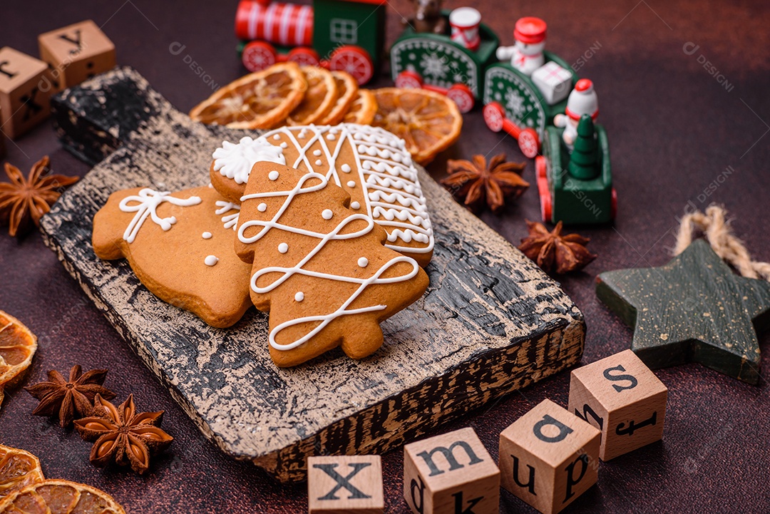 Lindos e deliciosos biscoitos de gengibre de Natal de inverno em um fundo texturizado de bronze.