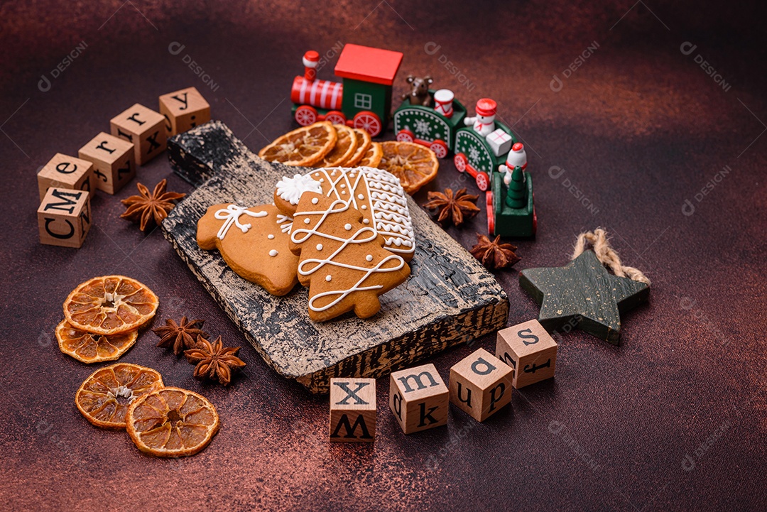 Lindos e deliciosos biscoitos de gengibre de Natal de inverno em um fundo texturizado de bronze.