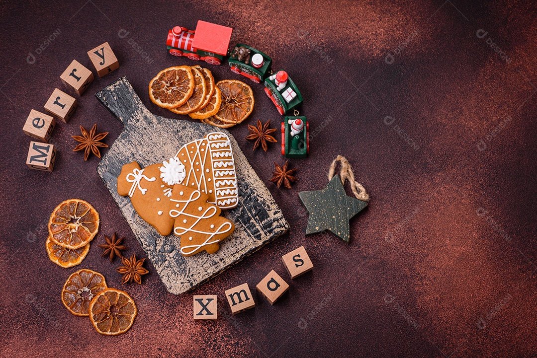 Lindos e deliciosos biscoitos de gengibre de Natal de inverno em um fundo texturizado de bronze.