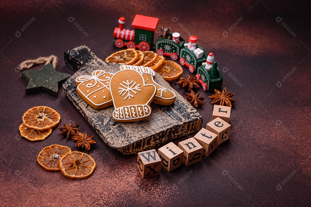 Lindos e deliciosos biscoitos de gengibre de Natal de inverno em um fundo texturizado de bronze.