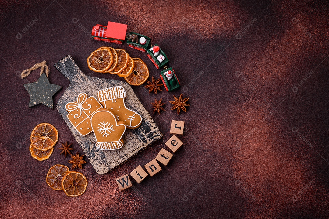 Lindos e deliciosos biscoitos de gengibre de Natal de inverno em um fundo texturizado de bronze.