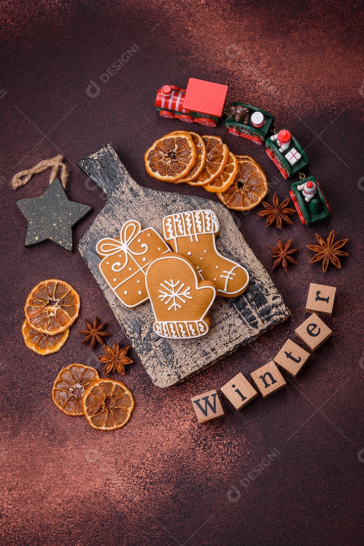 Lindos e deliciosos biscoitos de gengibre de Natal de inverno em um fundo texturizado de bronze.