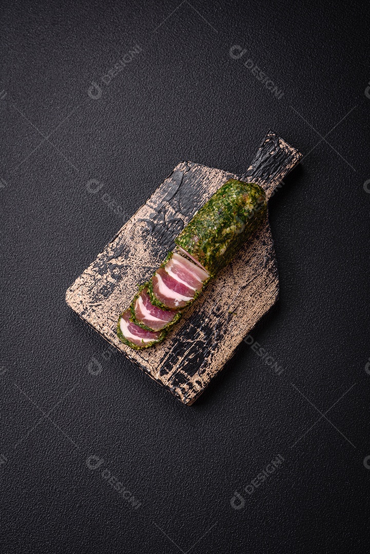 Deliciosas listras de bacon fresco com especiarias e sal sobre um fundo escuro de concreto