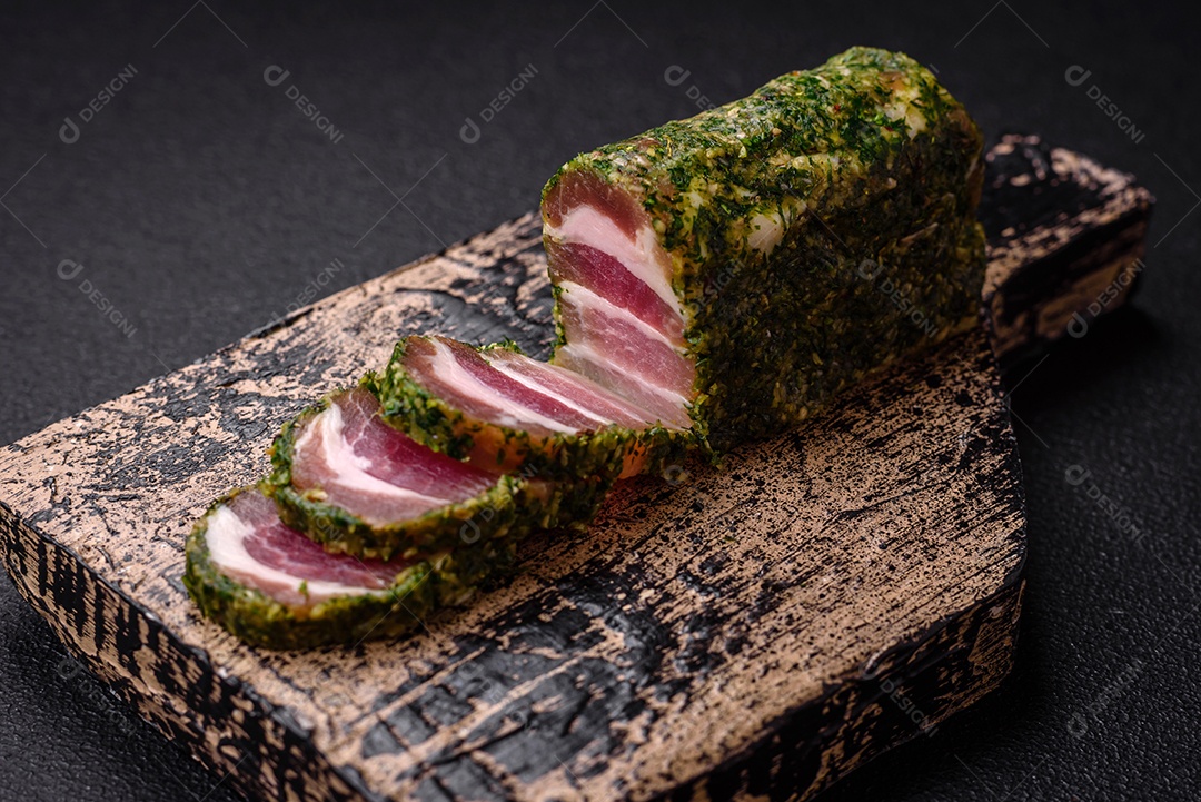 Deliciosas listras de bacon fresco com especiarias e sal sobre um fundo escuro de concreto