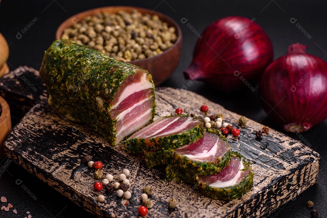 Deliciosas listras de bacon fresco com especiarias e sal sobre um fundo escuro de concreto