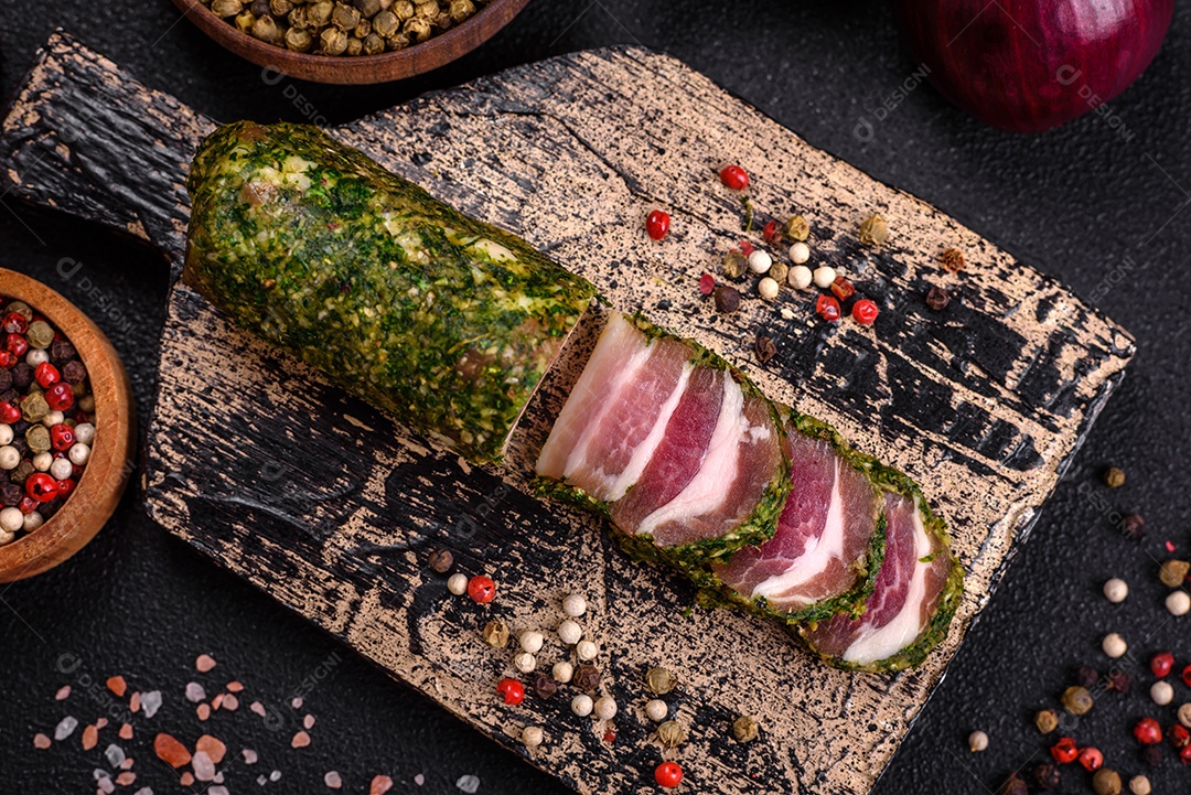 Deliciosas listras de bacon fresco com especiarias e sal sobre um fundo escuro de concreto