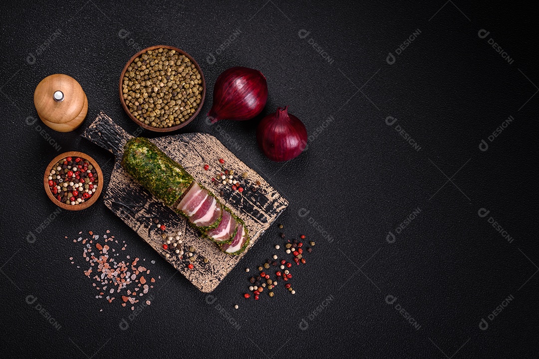 Deliciosas listras de bacon fresco com especiarias e sal sobre um fundo escuro de concreto