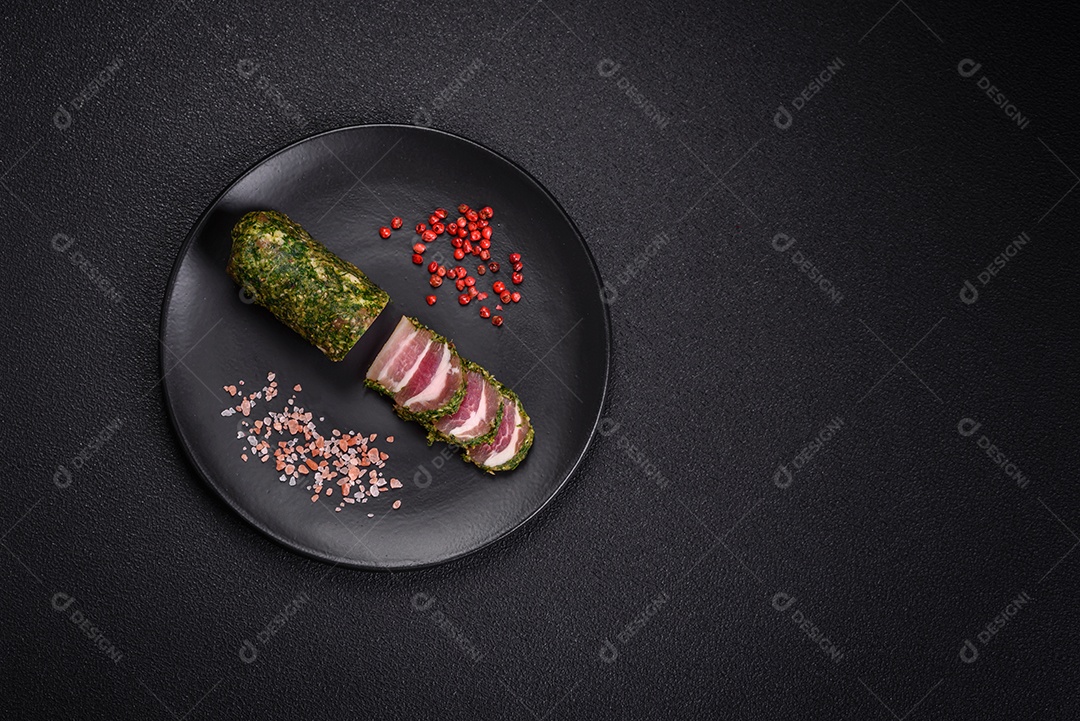 Deliciosas listras de bacon fresco com especiarias e sal sobre um fundo escuro de concreto