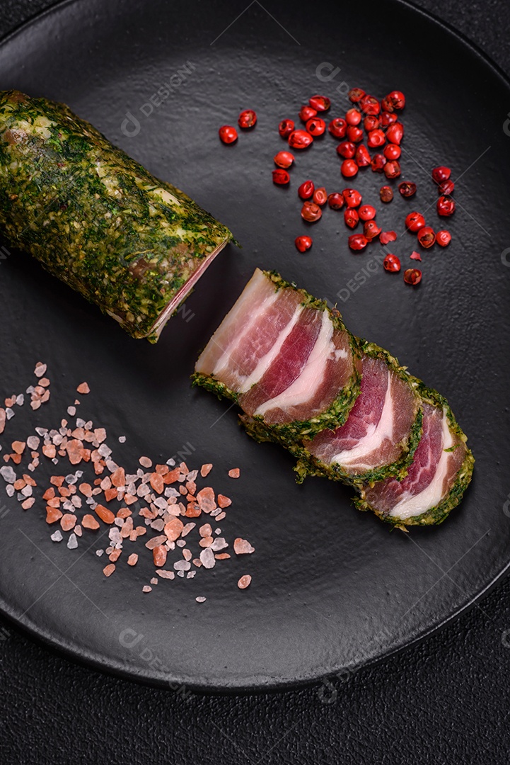 Deliciosas listras de bacon fresco com especiarias e sal sobre um fundo escuro de concreto