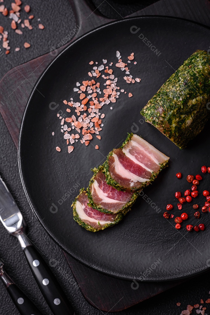 Deliciosas listras de bacon fresco com especiarias e sal sobre um fundo escuro de concreto